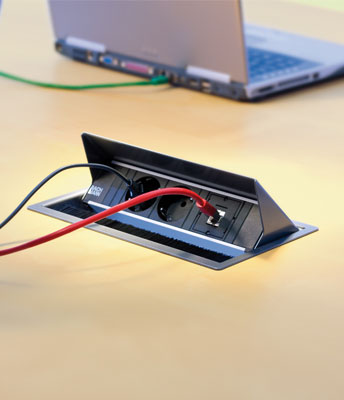 Una regleta con varios enchufes y conectores USB de bachmann se integra en una mesa de oficina instalada en Palma de Mallorca